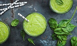 Green smoothie in glasses with straw
