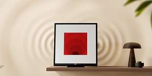 Samsung Music Frame på vegghylle ved siden av en lampe