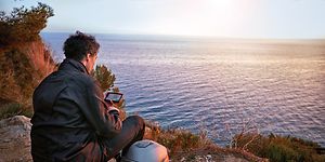 Motorsyklist som tar seg en pause på en strand