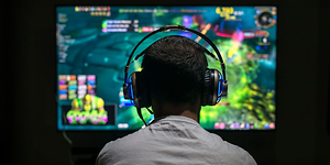 mann som sitter med gamingheadsett og spiller TV-spill