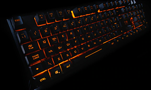 ADX sort gamingtastatur med oransje bakbelysning
