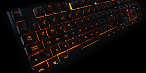 ADX sort gamingtastatur med oransje bakbelysning