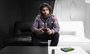 Mann holder en spillkontroll i et svart og hvitt rom med Nvidia Shield