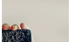 hånd med del av knust smarttelefon