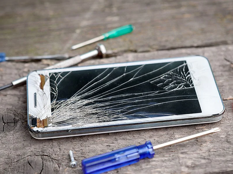 iphone med knust skjerm og verktøy rundt