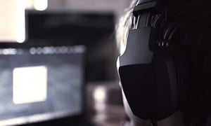 person med gaming-headsett foran dataskjerm