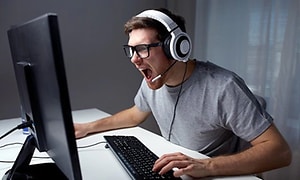 mann med gaming-headset skriker til pc-skjermen
