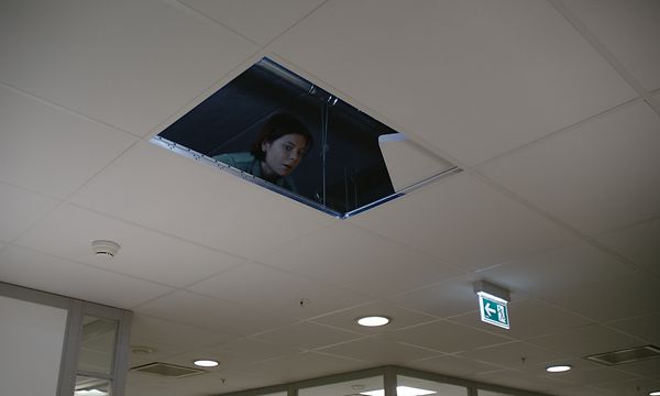 Kvinne som gjemmer seg i mellomtaket i kontoret