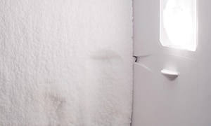 innsiden av kjøleskap med frost og is på