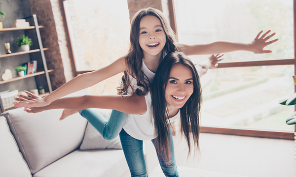 Indoor Climate hero banner with a girl and a mother pretending to fly together in the living room