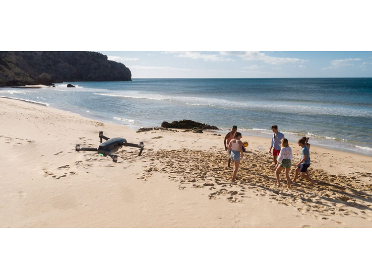 drone flyr over personer på en strand