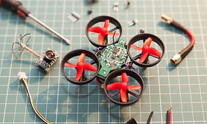 drone i deler på arbeidsbenk med verktøy