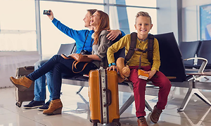 gutt med smartklokke og hans familie tar selfie på flyplass