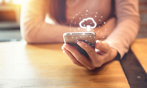 nærbilde av kvinne som holder smarttelefon med sky-symbol over
