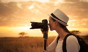 kvinne på safari med kamera på monopod