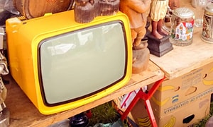 retro gul tv på bord sammen med andre retro elementer