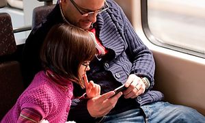 Mann og jente ser konsentrert på smarttelefon
