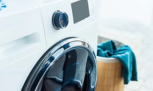 nærbilde av kombinert vaskemaskin og tørketrommel hvit på vaskerom