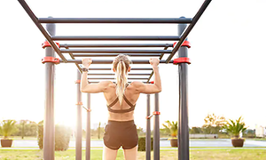 kvinne med sportsklokke gjør pull-ups