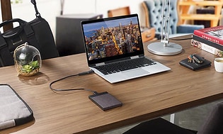 laptop og ekstern harddisk koblet sammen på et bord på hjemmekontor