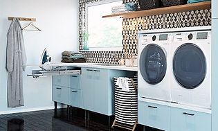 blått vaskerom med blå skuffer og vaskemaskin, tørketrommel og strykebrett