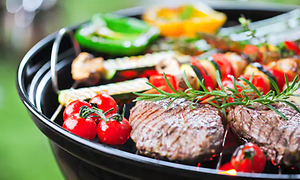 utendørs kullgrill med biff og grønnsaker på