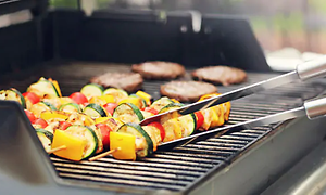 grønnsaksspyd blir snudd på gassgrill
